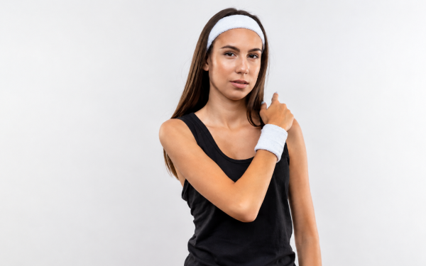 Mulher usando munhequeira esportiva branca no pulso para jogar tênis
